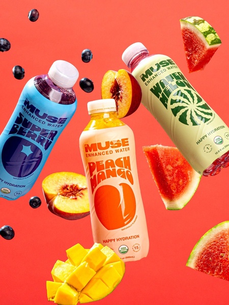 This creative features three distinct flavors of enhanced water surrounded by fresh, floating fruit ingredients against a high-contrast coral background.